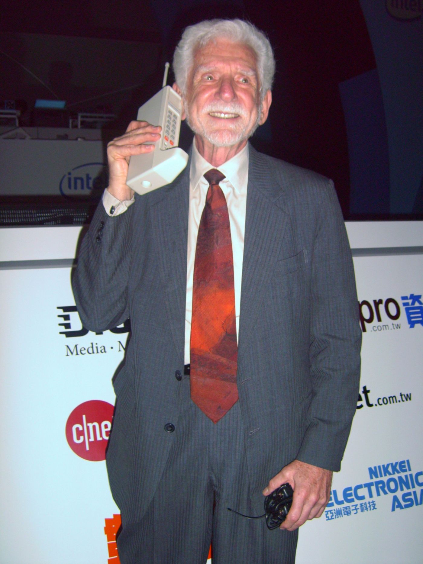Martin Cooper tenant le premier téléphone cellulaire